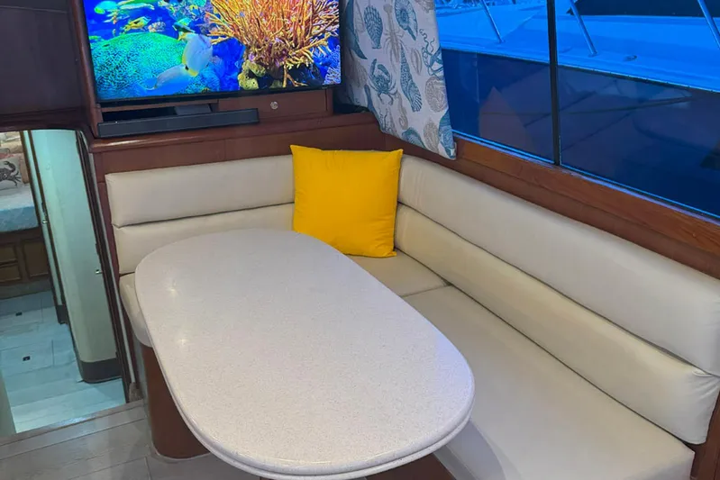 Happy Our's Yacht Photos Pics Interior of 1997 Ocean Yachts 48 Super Sport with cozy seating and vibrant decor.