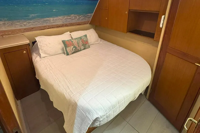 Happy Our's Yacht Photos Pics Cozy bedroom in 1997 Ocean Yachts 48 Super Sport with beach-themed decor.