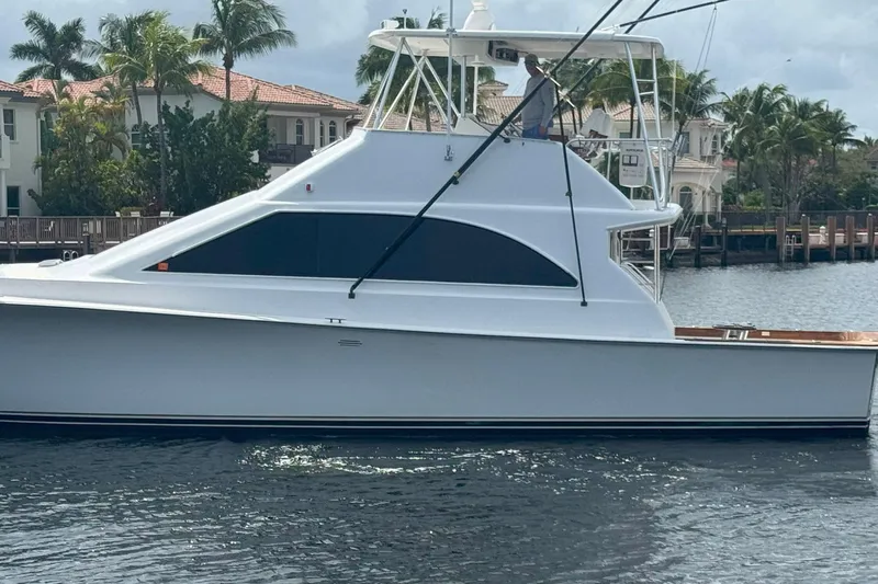 Happy Our's Yacht Photos Pics 1997 Ocean Yachts 48 Super Sport boat on water, with palm trees and houses in background.