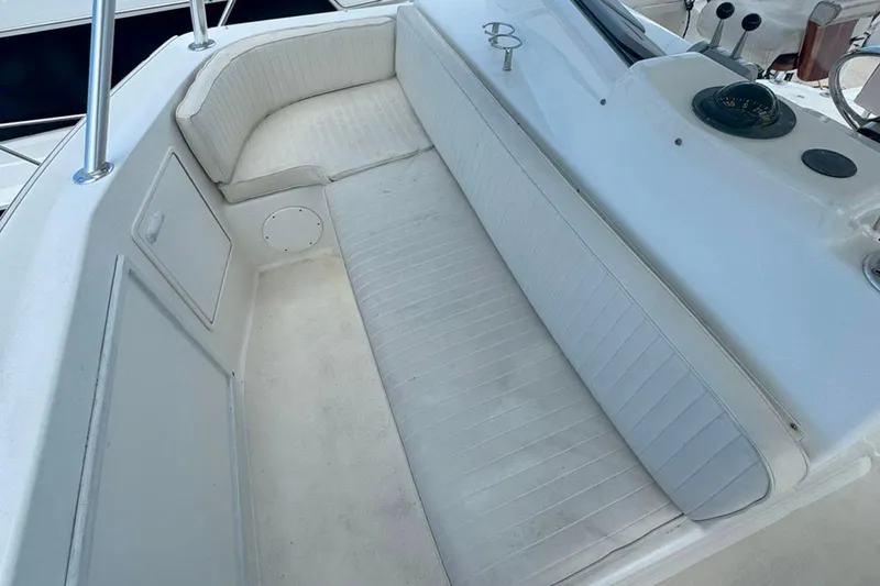 Happy Our's Yacht Photos Pics 1997 Ocean Yachts 48 Super Sport boat seating area with white cushioned bench.