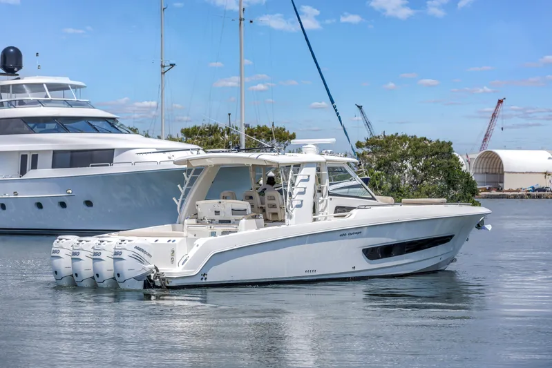  Yacht Photos Pics 2018 Boston Whaler 420 Outrage boat on calm water, docked near yachts.