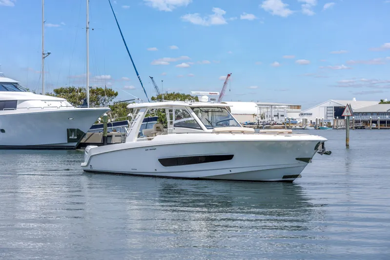  Yacht Photos Pics 2018 Boston Whaler 420 Outrage boat on calm water, docked near other vessels.
