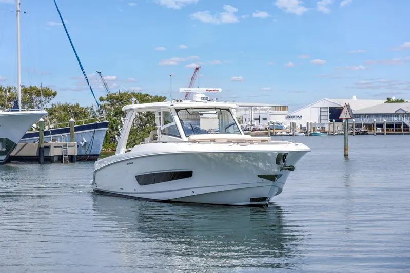  Yacht Photos Pics 2018 Boston Whaler 420 Outrage cruising in a marina under a clear blue sky.