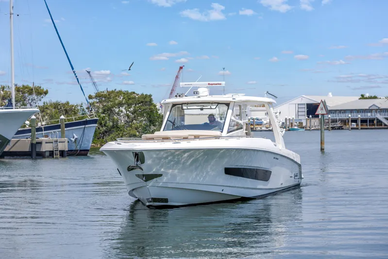  Yacht Photos Pics 2018 Boston Whaler 420 Outrage cruising in a marina under a clear blue sky.