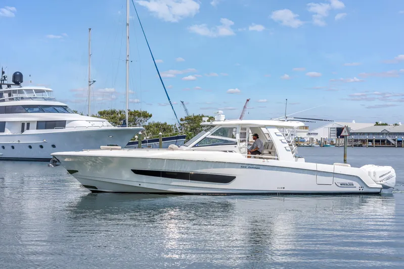  Yacht Photos Pics 2018 Boston Whaler 420 Outrage boat on calm water, with marina background.