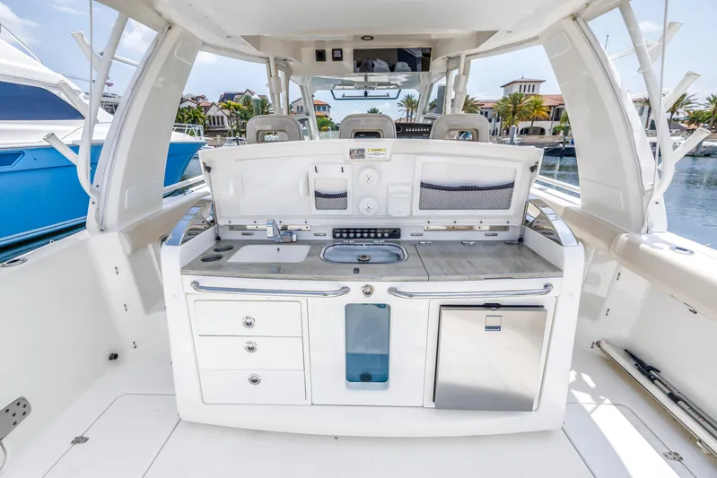  Yacht Photos Pics 2018 Boston Whaler 420 Outrage boat interior with kitchenette and seating area.