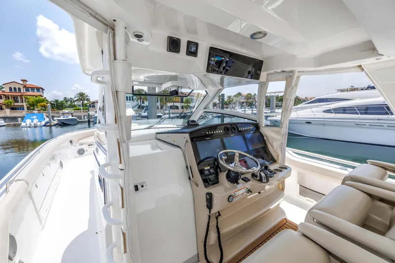  Yacht Photos Pics 2018 Boston Whaler 420 Outrage cockpit with modern controls, docked at a marina.