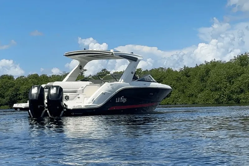  Yacht Photos Pics 2022 Sea Ray 310SLX OB boat on water, clear sky, lush greenery background.