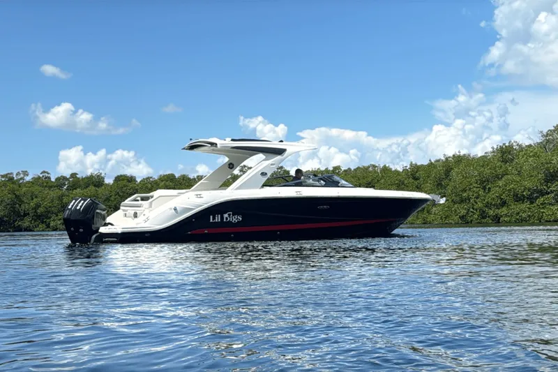  Yacht Photos Pics 2022 Sea Ray 310SLX OB boat on calm water with lush greenery background.