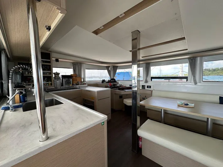 Uni Yacht Photos Pics Interior of 2023 Lagoon 46 catamaran with modern kitchen and dining area.