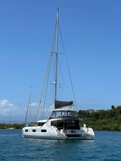 Uni Yacht Photos Pics 2023 Lagoon 46 catamaran sailing on calm waters under clear blue sky.
