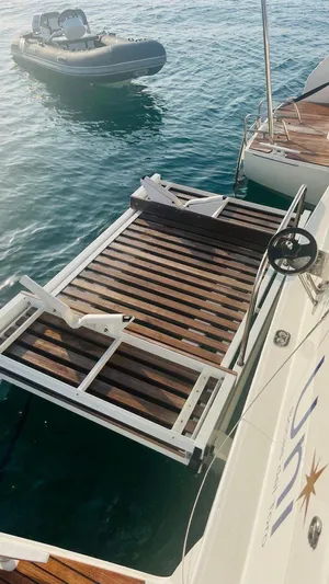 Uni Yacht Photos Pics 2023 Lagoon 46 yacht with wooden deck and inflatable boat on water.