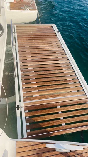 Uni Yacht Photos Pics 2023 Lagoon 46 yacht with wooden deck over clear blue water.