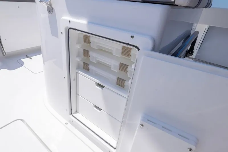  Yacht Photos Pics 2026 Sea Hunt Gamefish 25 boat storage compartment with organized tackle boxes and drawers.