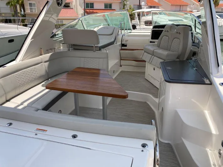 2021 Sea Ray 350 Sundancer @ Cancun Yacht Photos Pics 2021 Sea Ray Sundancer 350 interior with seating, wooden table, and helm.