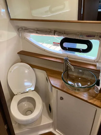 2021 Sea Ray 350 Sundancer @ Cancun Yacht Photos Pics 2021 Sea Ray Sundancer 350 bathroom with toilet, glass sink, and porthole window.