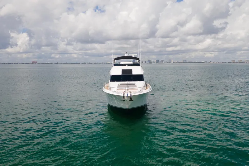 Living The Dream Yacht Photos Pics 2008 Lazzara 84 Open Bridge yacht on calm ocean with cloudy sky backdrop.