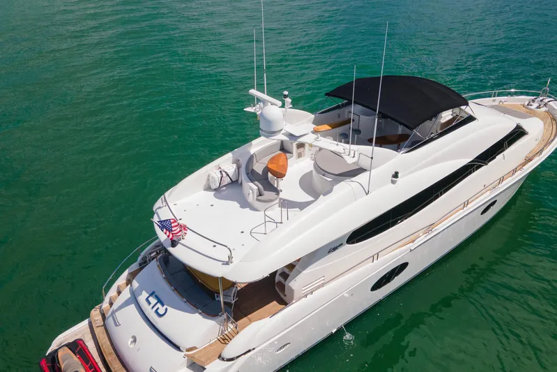 Living The Dream Yacht Photos Pics 2008 Lazzara 84 Open Bridge yacht on clear turquoise water, aerial view.