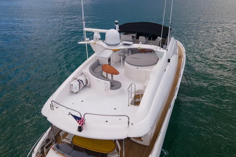 Living The Dream Yacht Photos Pics 2008 Lazzara 84 Open Bridge yacht on calm water, featuring spacious deck and seating area.