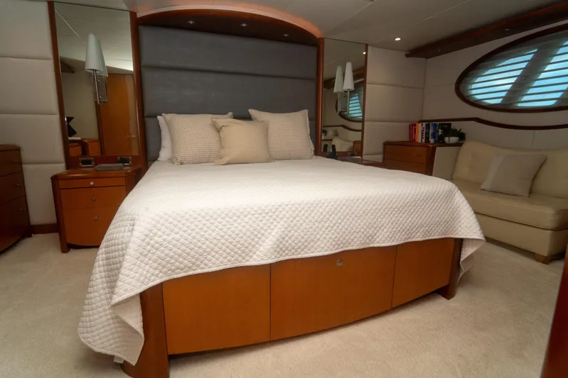 Living The Dream Yacht Photos Pics Luxurious bedroom interior on 2008 Lazzara 84 Open Bridge yacht, featuring elegant bedding and wood accents.