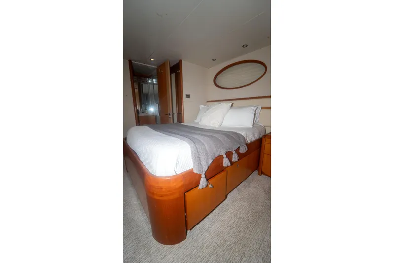 Living The Dream Yacht Photos Pics Luxurious bedroom interior on 2008 Lazzara 84 Open Bridge yacht, featuring elegant wood finishes.