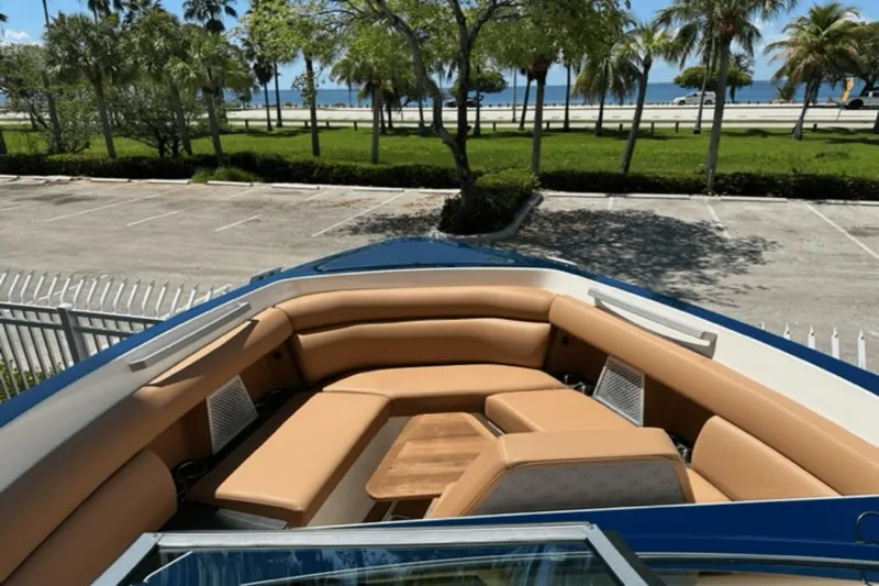  Yacht Photos Pics 2022 Aviara AV32 Outboard boat with tan seating, parked near a scenic waterfront.