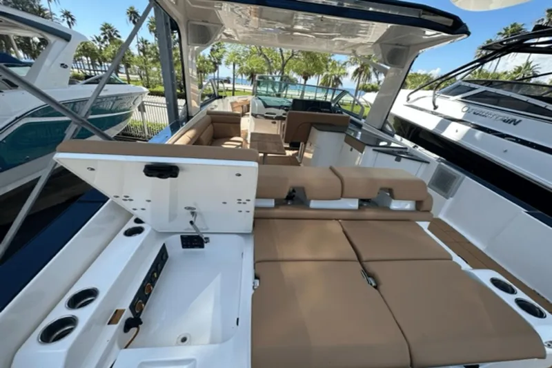  Yacht Photos Pics 2022 Aviara AV32 Outboard luxury boat interior with tan seating and open storage compartment.