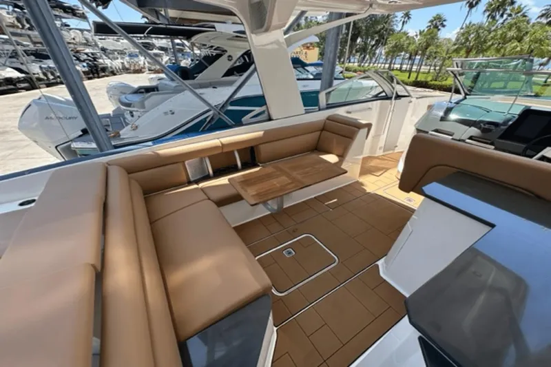  Yacht Photos Pics 2022 Aviara AV32 Outboard boat interior with tan seating and wooden table.