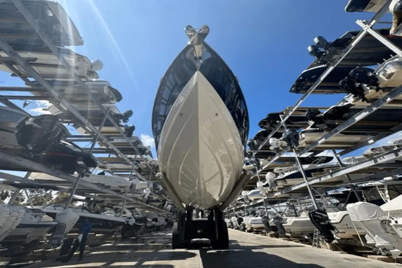  Yacht Photos Pics 2022 Aviara AV32 Outboard boat in storage facility under clear blue sky.