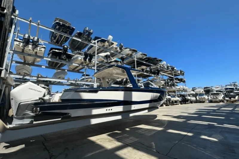  Yacht Photos Pics 2022 Aviara AV32 Outboard boat in storage facility under clear blue sky.