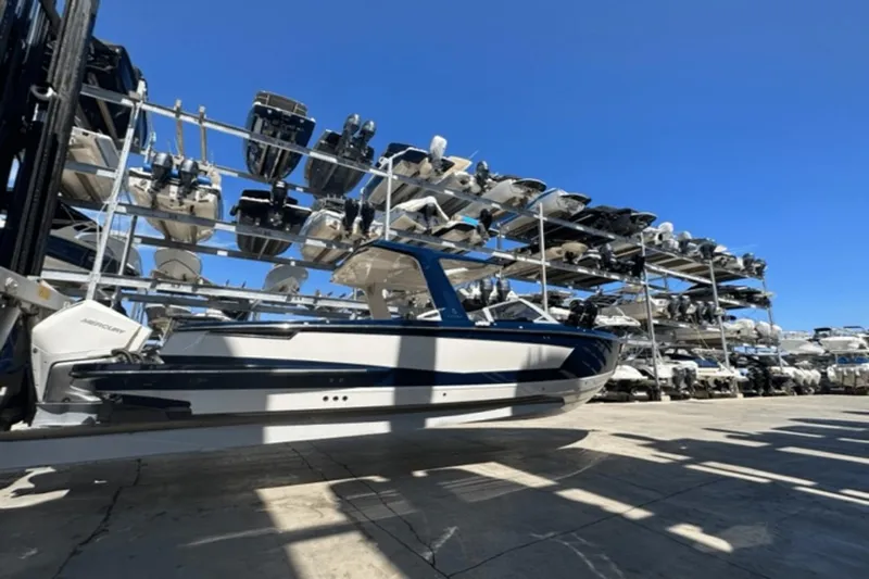  Yacht Photos Pics 2022 Aviara AV32 Outboard boat in storage facility under clear blue sky.