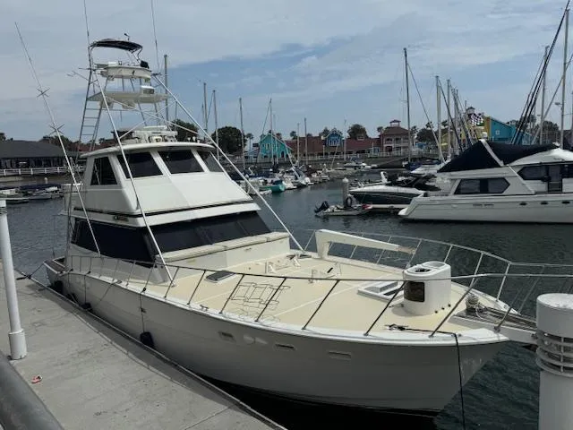 Andiamo Yacht Photos Pics 1982 Hatteras Enclosed Flybridge yacht docked in a marina with sailboats.