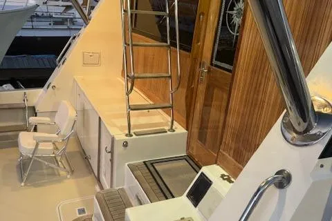 Andiamo Yacht Photos Pics 1982 Hatteras Enclosed Flybridge yacht deck with ladder and seating area.