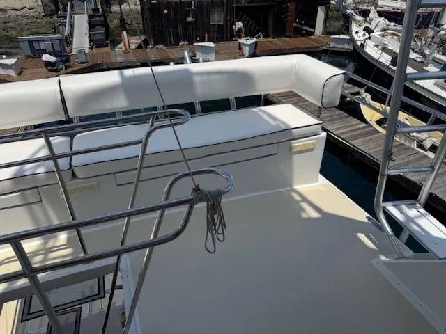 Andiamo Yacht Photos Pics 1982 Hatteras Enclosed Flybridge yacht deck with seating, docked at marina.