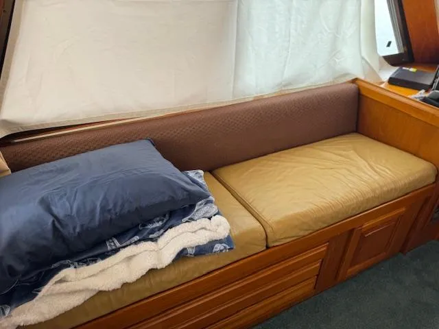 Andiamo Yacht Photos Pics 1982 Hatteras Enclosed Flybridge interior with cushioned seating and pillows.