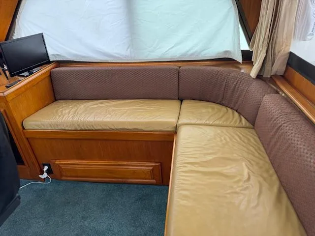 Andiamo Yacht Photos Pics 1982 Hatteras Enclosed Flybridge interior with brown leather seating and small TV.