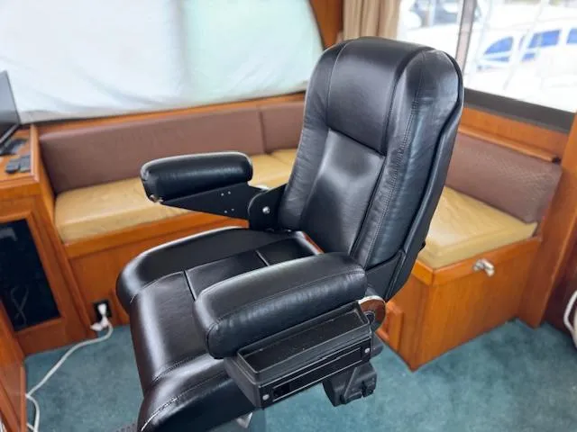 Andiamo Yacht Photos Pics Black captain's chair in 1982 Hatteras Enclosed Flybridge yacht interior.
