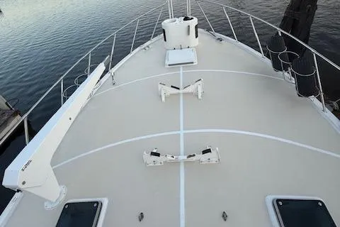 Andiamo Yacht Photos Pics 1982 Hatteras Enclosed Flybridge boat deck with railing, docked on calm water.