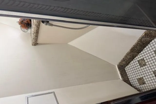 Andiamo Yacht Photos Pics Shower area in 1982 Hatteras Enclosed Flybridge with granite accents and tiled floor.