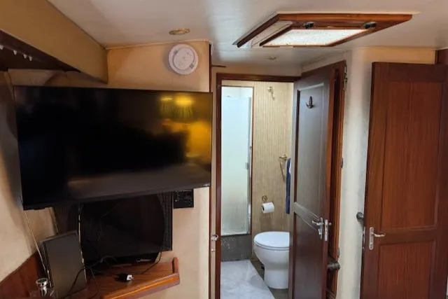 Andiamo Yacht Photos Pics Interior of 1982 Hatteras Enclosed Flybridge with TV and bathroom view.