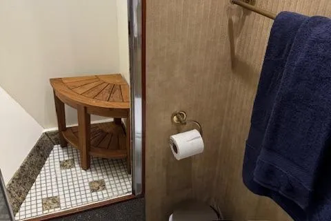 Andiamo Yacht Photos Pics 1982 Hatteras Enclosed Flybridge bathroom with wooden shelf, towel, and tiled floor.