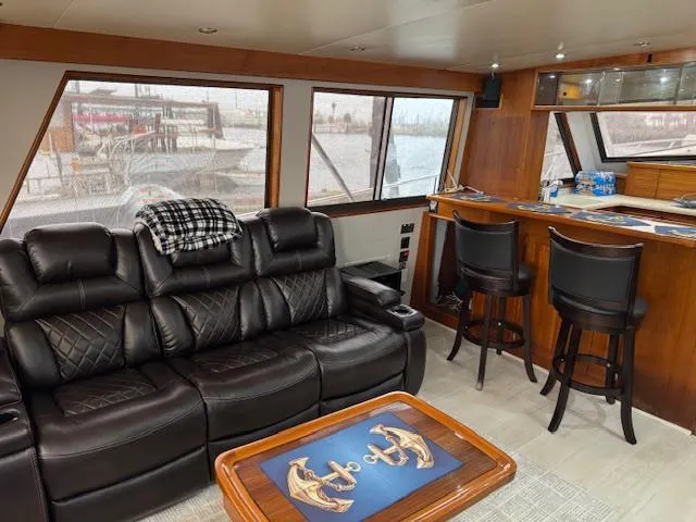 Andiamo Yacht Photos Pics Luxurious interior of 1982 Hatteras Enclosed Flybridge with leather seating and nautical decor.