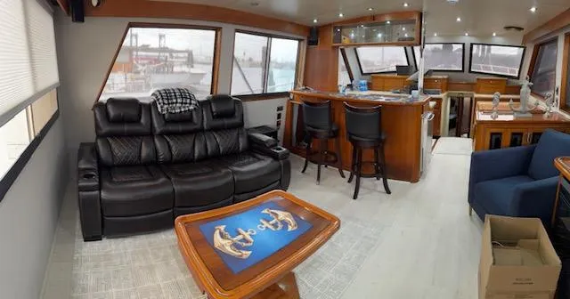 Andiamo Yacht Photos Pics Luxurious interior of a 1982 Hatteras Enclosed Flybridge yacht with leather seating and nautical decor.