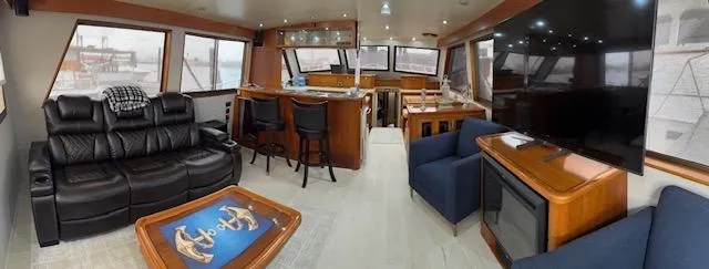 Andiamo Yacht Photos Pics Luxurious interior of a 1982 Hatteras Enclosed Flybridge yacht with leather seating and large windows.