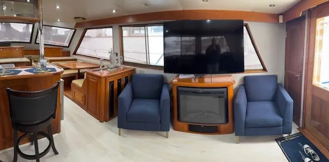 Andiamo Yacht Photos Pics Interior of 1982 Hatteras Enclosed Flybridge with modern seating and large TV.