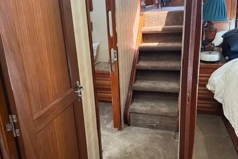 Andiamo Yacht Photos Pics Interior of 1982 Hatteras Enclosed Flybridge with wooden doors and carpeted stairs.