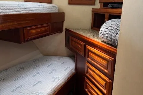 Andiamo Yacht Photos Pics 1982 Hatteras Enclosed Flybridge cabin with wooden bunk beds and storage drawers.