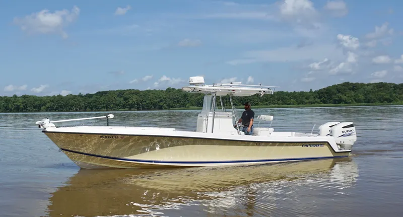  Yacht Photos Pics 2003 Contender 31 Open boat on calm water with a person at the helm.