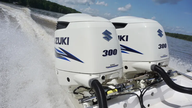  Yacht Photos Pics Twin Suzuki 300 outboard engines powering a 2003 Contender 31 Open boat on a lake.