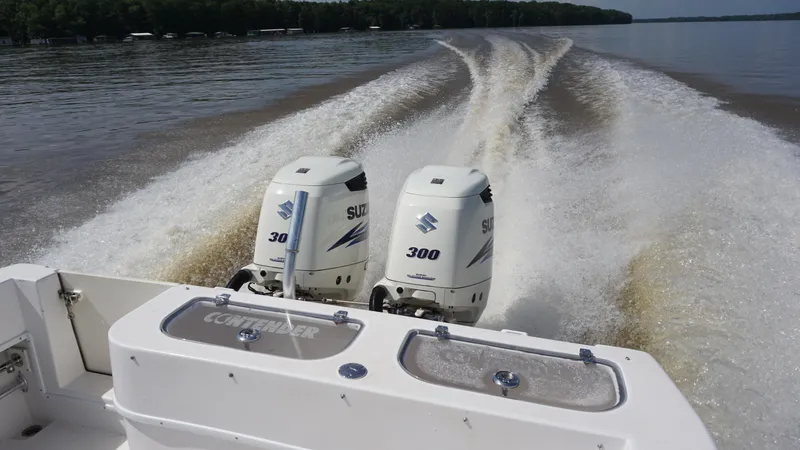  Yacht Photos Pics 2003 Contender 31 Open boat with dual Suzuki 300 engines cruising on a lake.